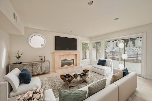 living room featuring light tile patterned flooring and a premium fireplace