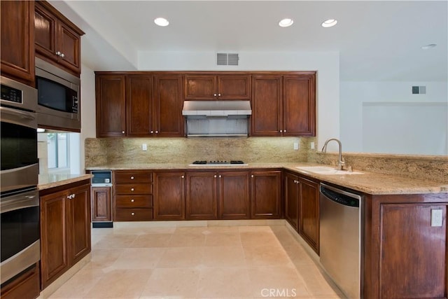 kitchen featuring sink, light stone counters, tasteful backsplash, kitchen peninsula, and stainless steel appliances