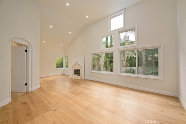 unfurnished living room featuring light hardwood / wood-style floors and a high ceiling