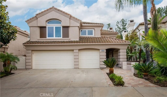 mediterranean / spanish-style house with a garage