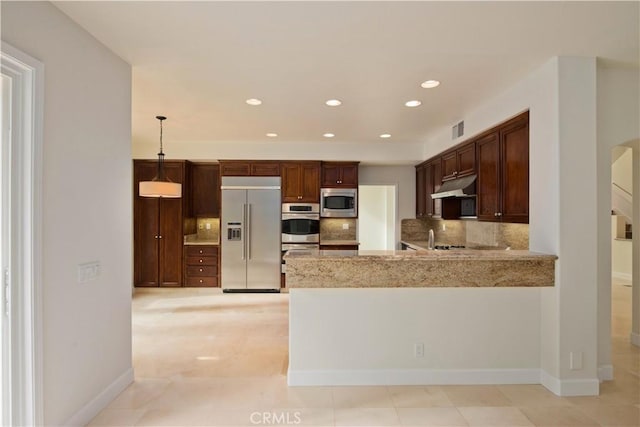 kitchen with sink, hanging light fixtures, backsplash, built in appliances, and kitchen peninsula