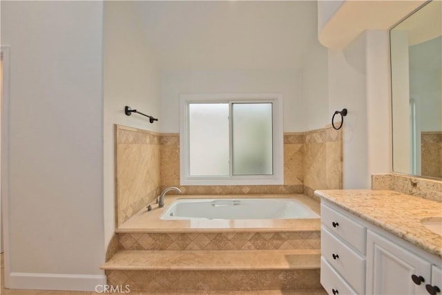 bathroom with vanity and tiled tub