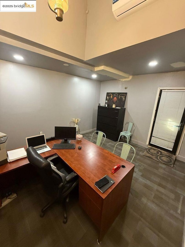 office area with a towering ceiling and a wall mounted AC