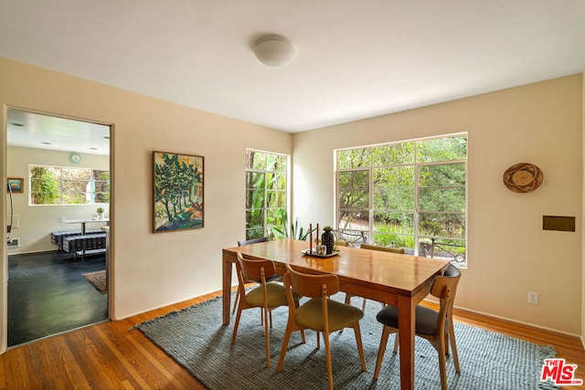 dining room featuring a healthy amount of sunlight and dark hardwood / wood-style floors