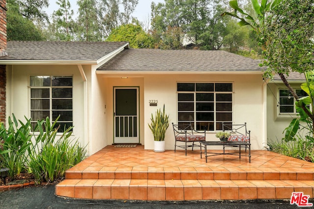 view of exterior entry with a patio