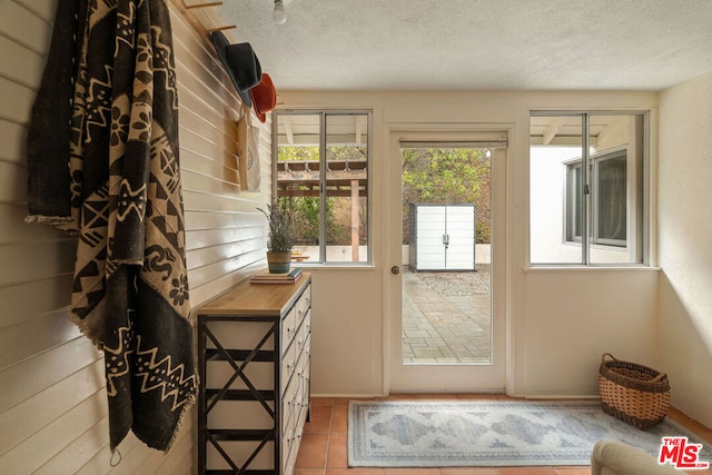 entryway with a textured ceiling and light tile patterned floors