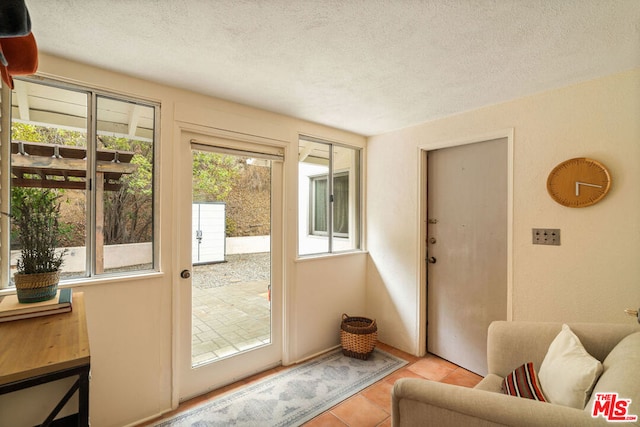 entryway featuring a textured ceiling and light tile patterned flooring