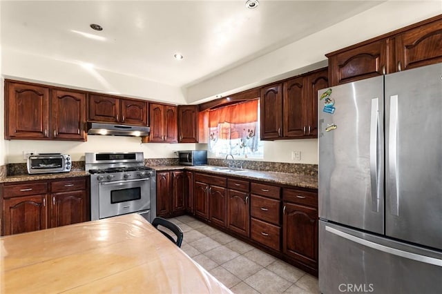 kitchen featuring dark stone countertops, appliances with stainless steel finishes, sink, and light tile patterned floors