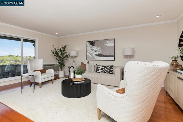 living room with hardwood / wood-style floors, ornamental molding, and an AC wall unit