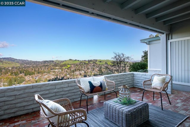 balcony featuring a mountain view, an outdoor living space, and a patio