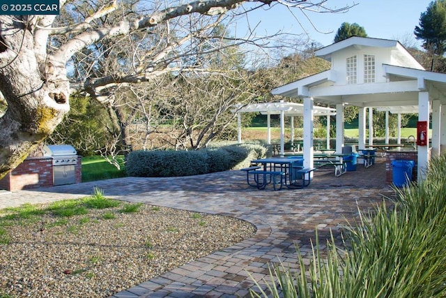 exterior space featuring exterior kitchen, a pergola, and a patio area