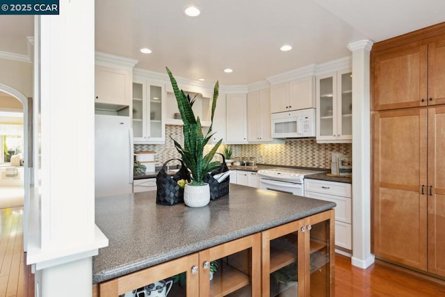 kitchen with white cabinets, white appliances, and decorative backsplash