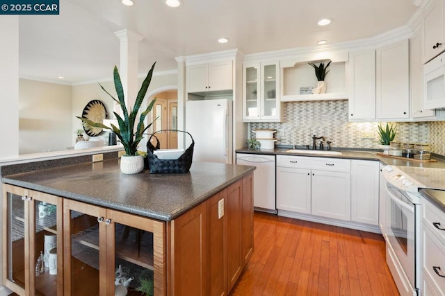 kitchen with sink, white cabinetry, crown molding, white appliances, and backsplash