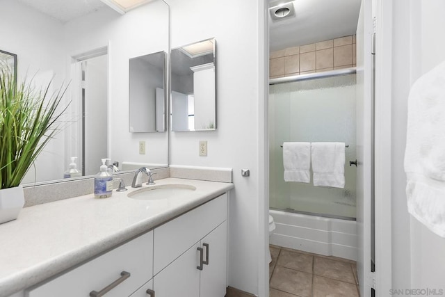 full bathroom with tile patterned flooring, vanity, toilet, and combined bath / shower with glass door