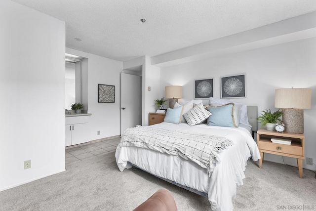 bedroom with carpet floors and a textured ceiling