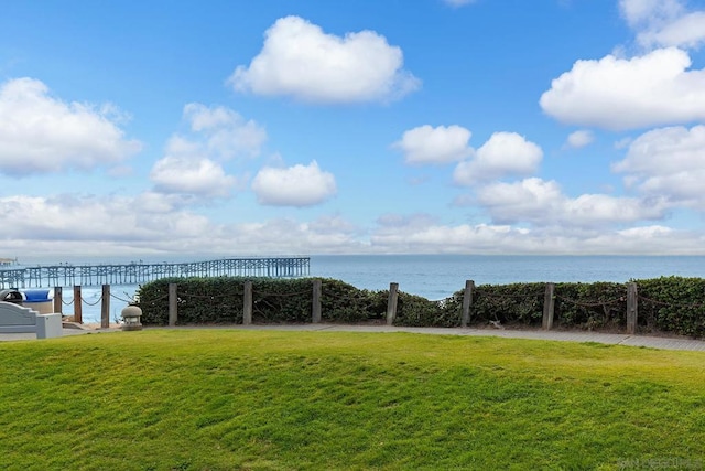 view of home's community with a water view and a yard