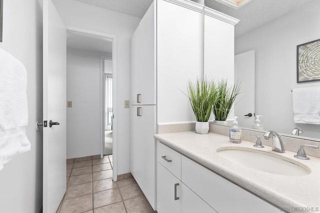 bathroom featuring tile patterned flooring, vanity, and a textured ceiling