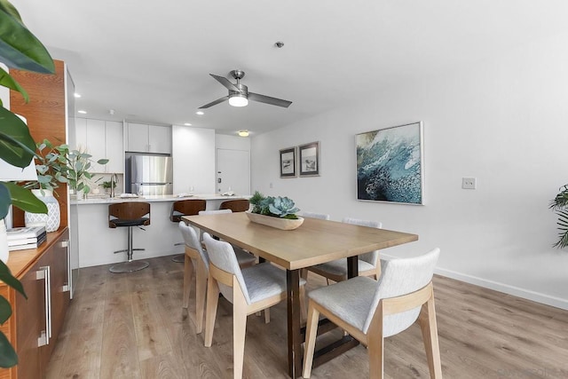 dining area featuring ceiling fan, sink, and light hardwood / wood-style flooring