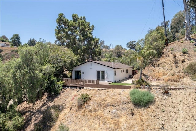 rear view of property featuring a deck and a patio area