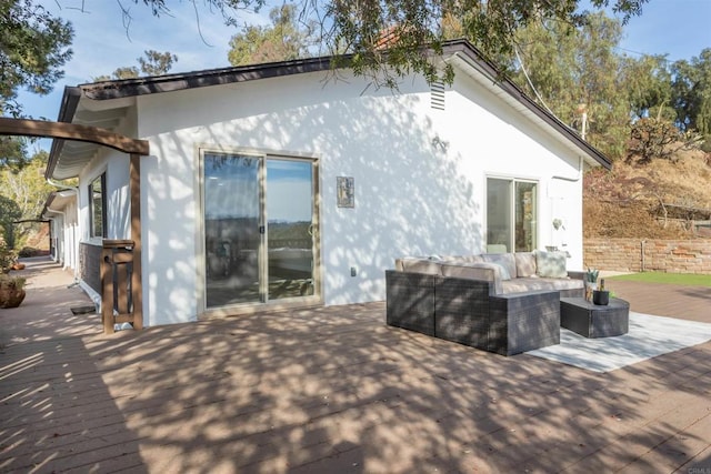 rear view of property featuring a wooden deck and an outdoor living space