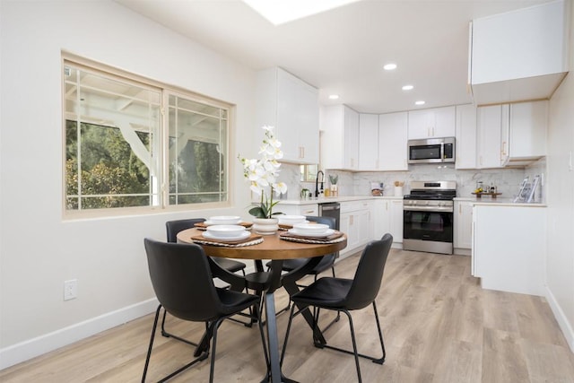 dining area with sink and light wood-type flooring