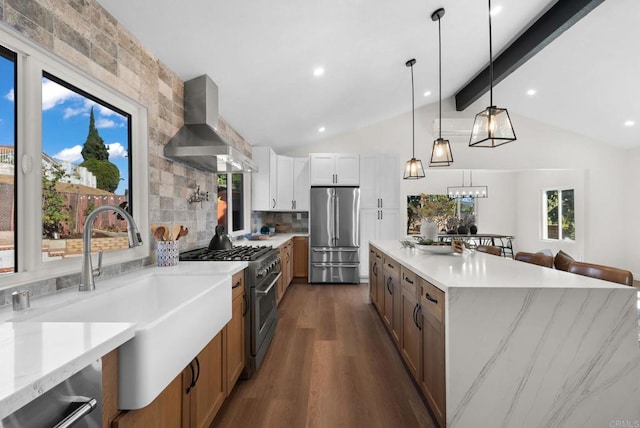 kitchen with pendant lighting, white cabinetry, stainless steel appliances, light stone counters, and wall chimney exhaust hood