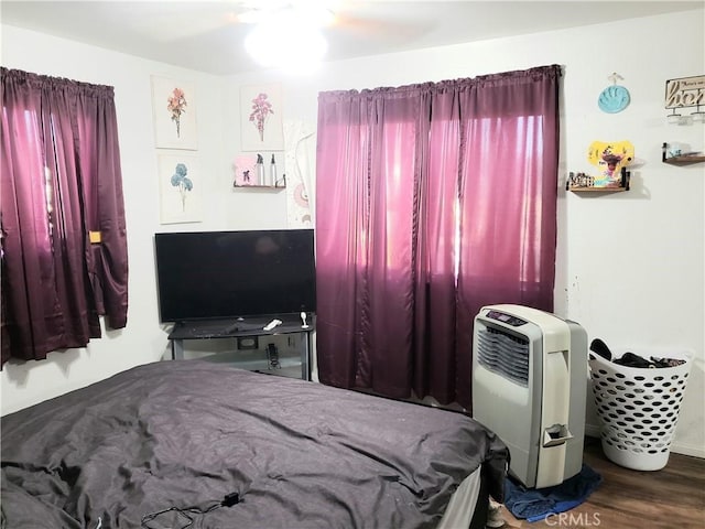 bedroom featuring dark hardwood / wood-style floors, heating unit, and ceiling fan