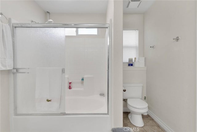 bathroom with tile patterned flooring, bath / shower combo with glass door, and toilet