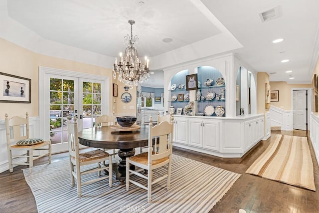 dining space with hardwood / wood-style flooring, a tray ceiling, and french doors