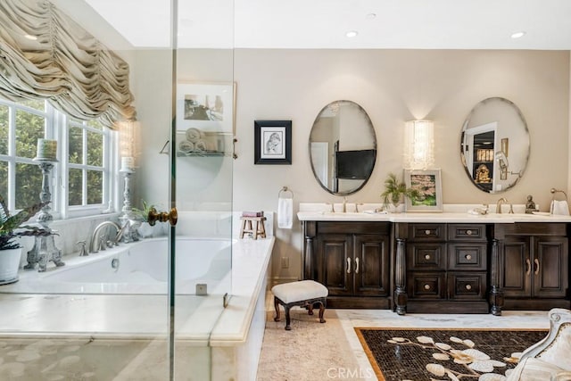 bathroom with a relaxing tiled tub and vanity