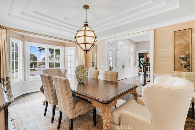 dining space featuring a notable chandelier, a tray ceiling, and hardwood / wood-style flooring