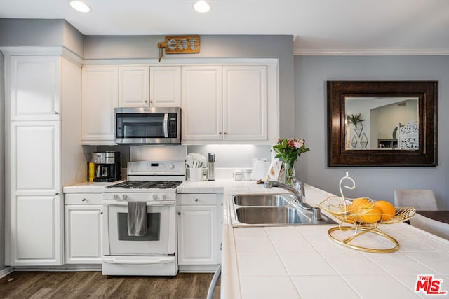 kitchen with sink, white gas stove, white cabinetry, tile counters, and dark hardwood / wood-style flooring