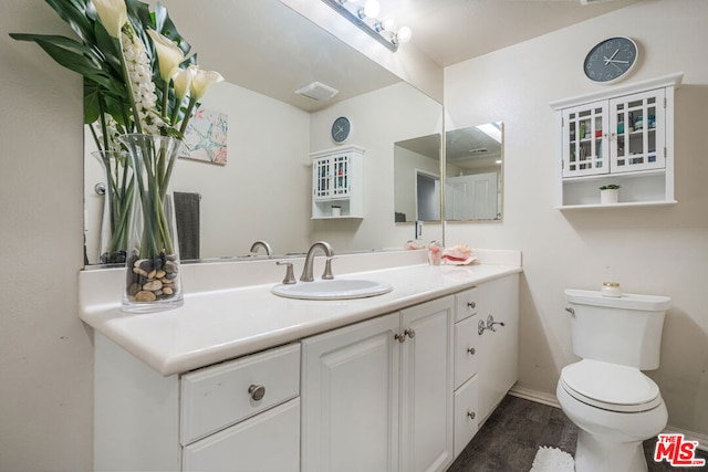 bathroom featuring vanity, wood-type flooring, and toilet