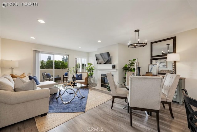 living room with a chandelier and light hardwood / wood-style flooring