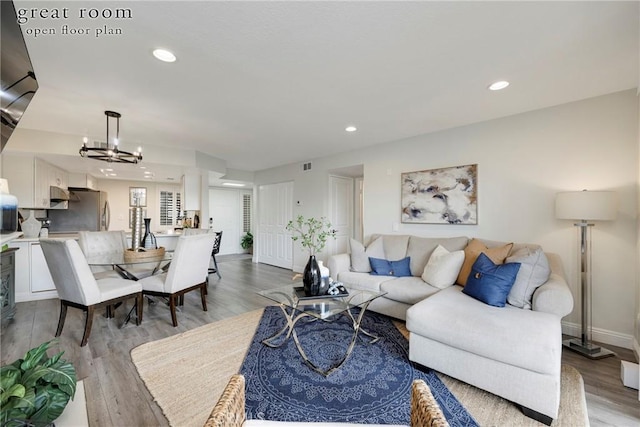 living room featuring a notable chandelier and light hardwood / wood-style floors