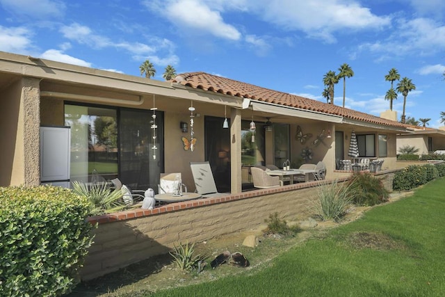 rear view of house with a patio area and a lawn