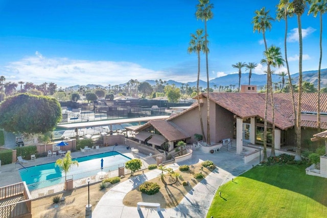 view of swimming pool featuring a mountain view, a yard, and a patio area