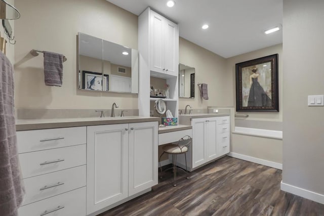 bathroom with vanity, hardwood / wood-style floors, and a tub to relax in