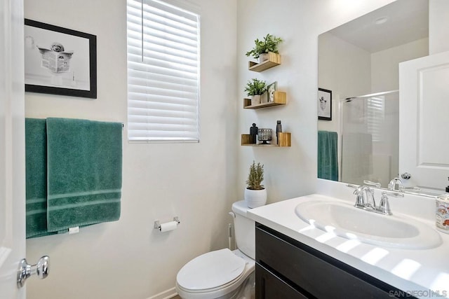 bathroom featuring vanity, toilet, and a shower with door