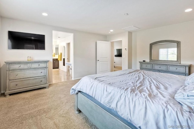 carpeted bedroom featuring ensuite bath