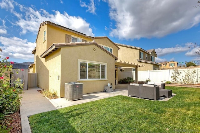 back of house featuring an outdoor living space, central air condition unit, a patio, and a lawn