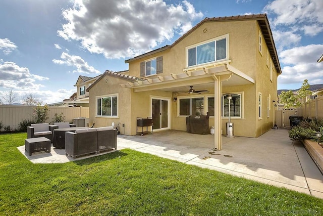 back of house featuring an outdoor living space, a patio, a yard, and ceiling fan