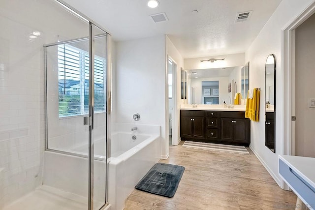 bathroom featuring vanity, shower with separate bathtub, and hardwood / wood-style floors