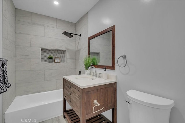 full bathroom with vanity, tiled shower / bath, and toilet