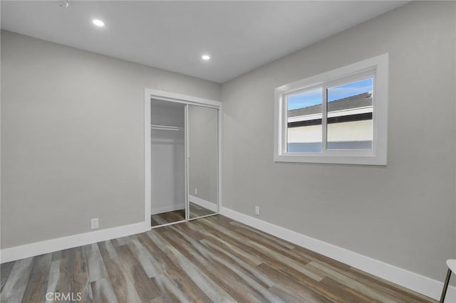 unfurnished bedroom with wood-type flooring and a closet