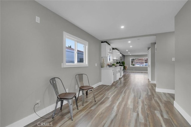 hall with sink and light hardwood / wood-style flooring