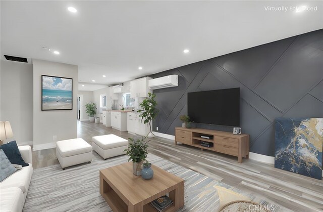 living room featuring a wall mounted air conditioner and light wood-type flooring