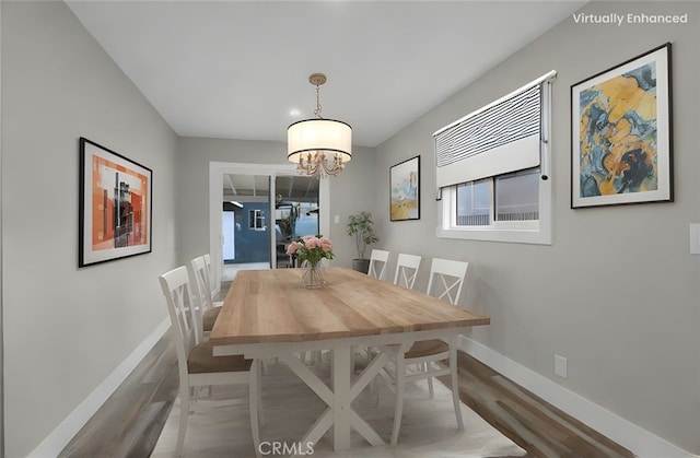 dining room featuring wood-type flooring and a chandelier