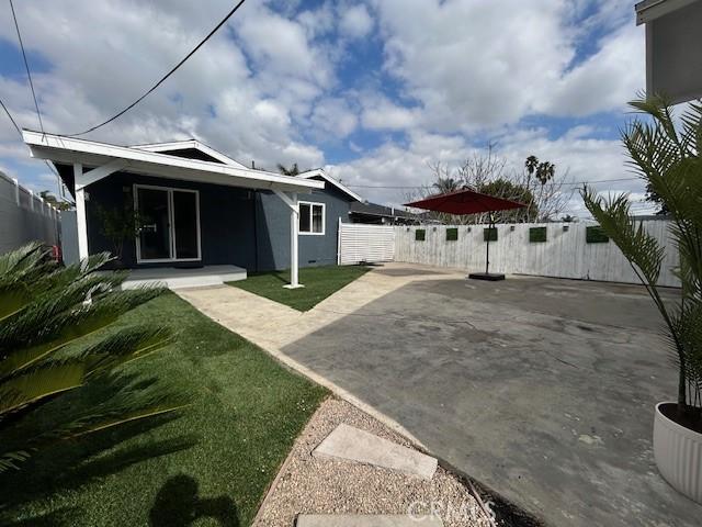 back of property with a patio area and a lawn