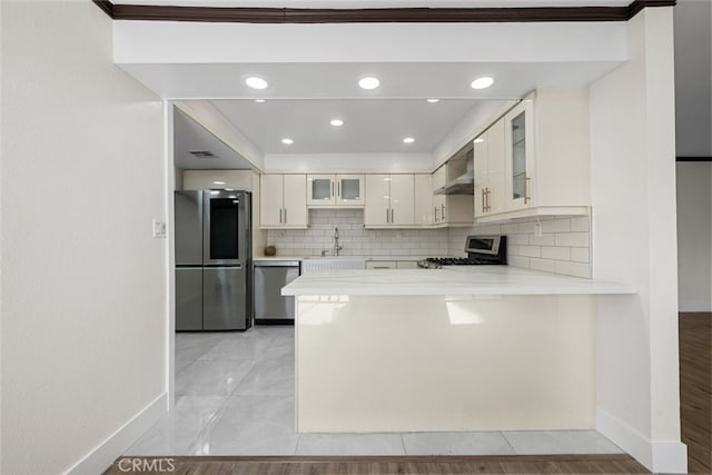 kitchen with sink, decorative backsplash, wall chimney exhaust hood, and appliances with stainless steel finishes